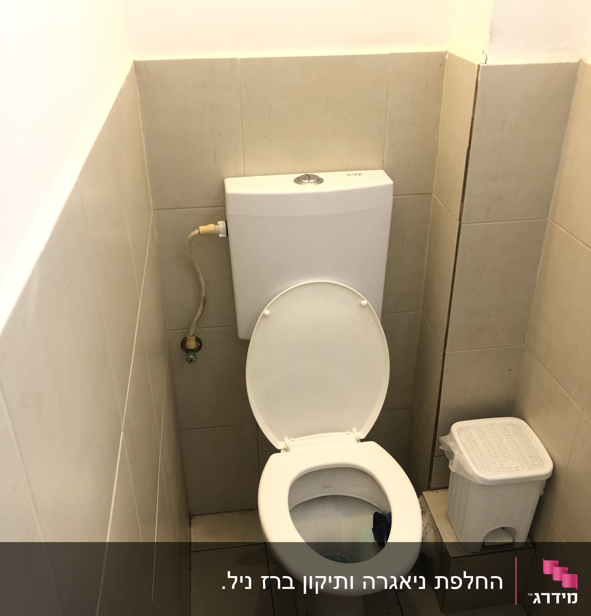 אסלה עם מכסה פתוח וצינור מים מחובר